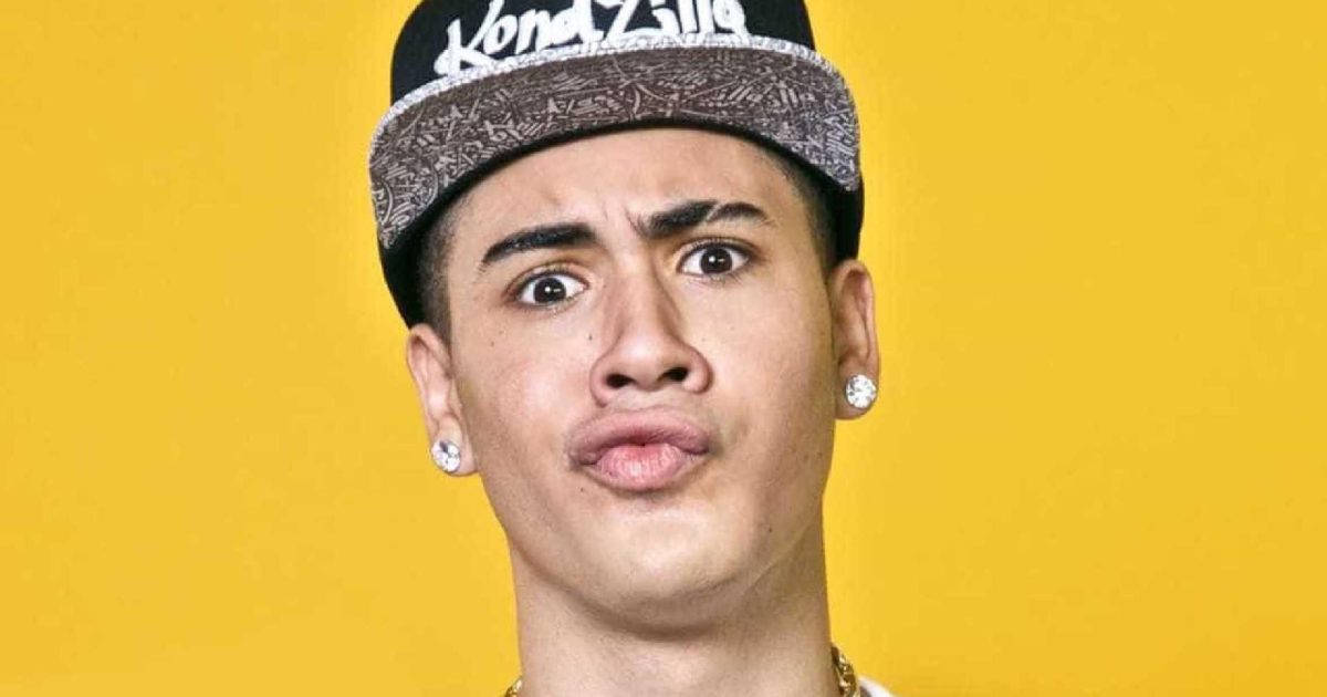 pout 桌布 壁紙 — 一名年輕男子露出驚訝表情，戴著黑色和灰色的帽子，背景是明亮的黃色。