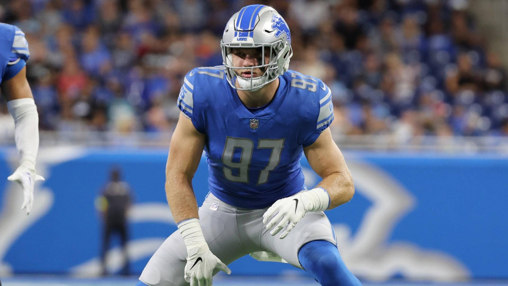 NFL 美式足球 桌布 壁紙 — 一名底特律雄獅隊的足球員身穿藍銀色制服，在比賽中於球場上激烈蹲伏。