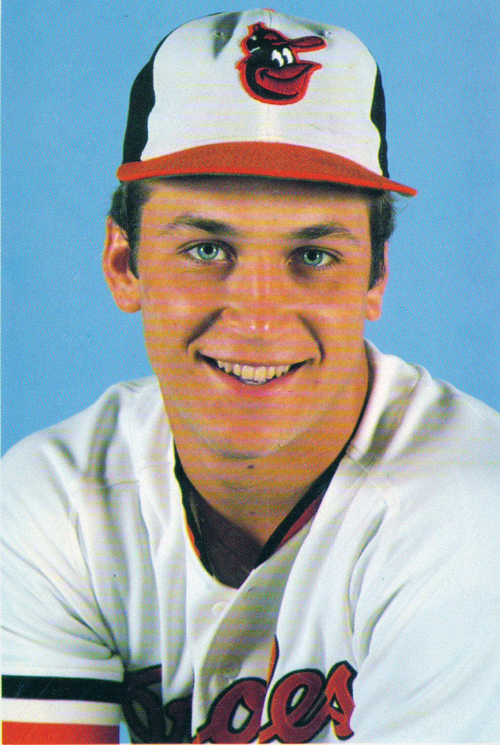 cal ripken jr 桌布 壁紙 — 一名微笑的棒球運動員身穿巴爾的摩金鶯隊制服，在純藍色攝影棚背景前擺姿勢。