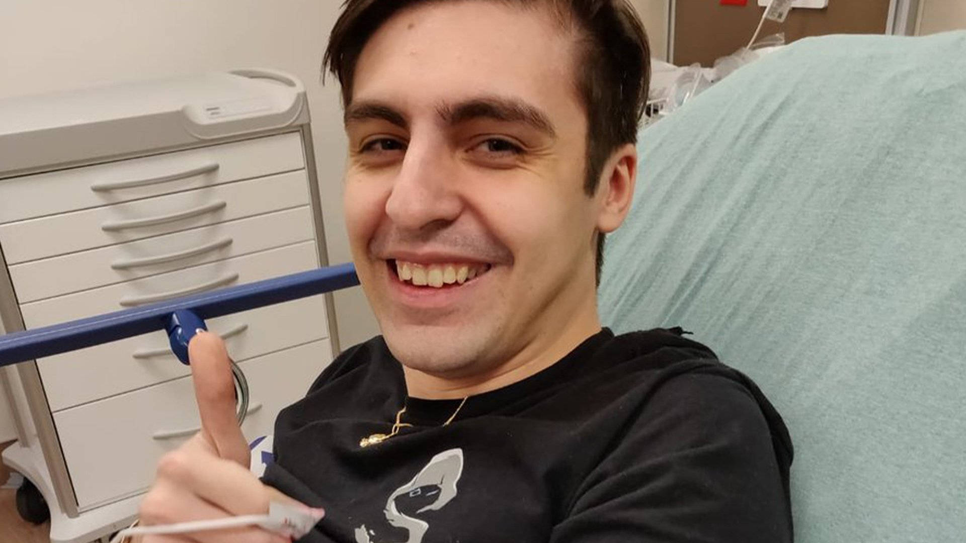 Shroud 桌布 壁紙 — 一名微笑的男子在醫院床上豎起大拇指，同時拿著溫度計。