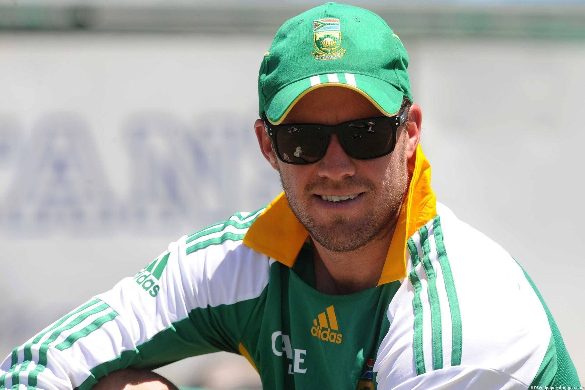 Ab De Villiers 桌布 壁紙 — 一名微笑的男子身穿綠色和黃色的南非板球制服和帽子，在明亮的陽光下自信地在戶外擺姿勢。