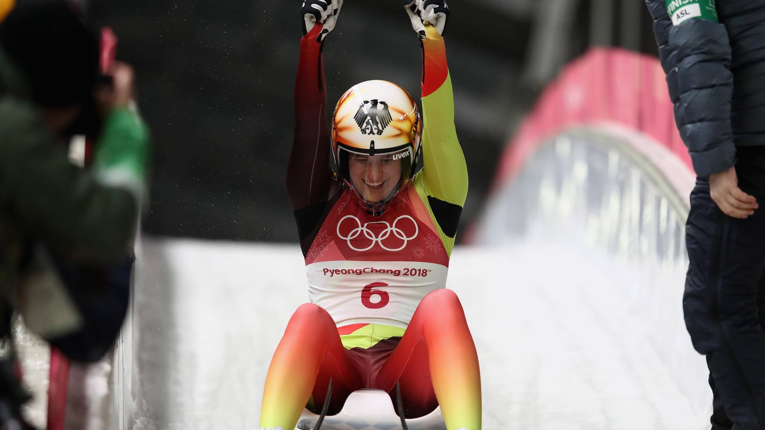 luge 桌布 壁紙 — 一名德國雪車運動員在2018年平昌冬季奧運會上，在雪地上高舉雙臂慶祝勝利。