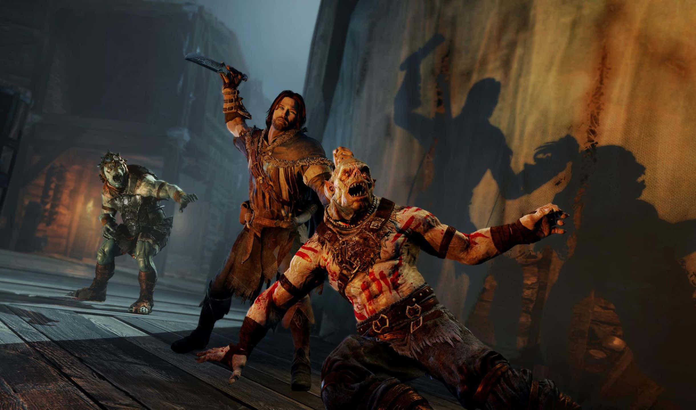 2440x1440 Shadow Of Mordor 桌布 壁紙 — 一名戰士在骯髒的地牢中砍向一個怪誕的殭屍-like 生物，搖曳的火把光芒投射出戲劇性的陰影。
