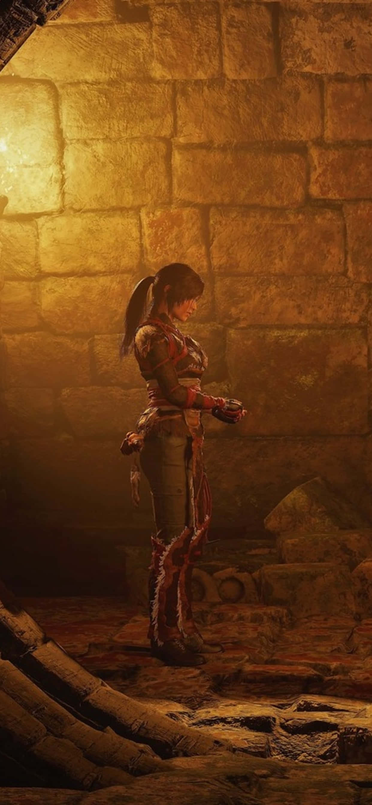 Pixel 3 Shadow Of The Tomb Raider 桌布 壁紙 — 一名戰士站在昏暗的石頭地牢中，沐浴在從上方灑下的溫暖金色光芒中。