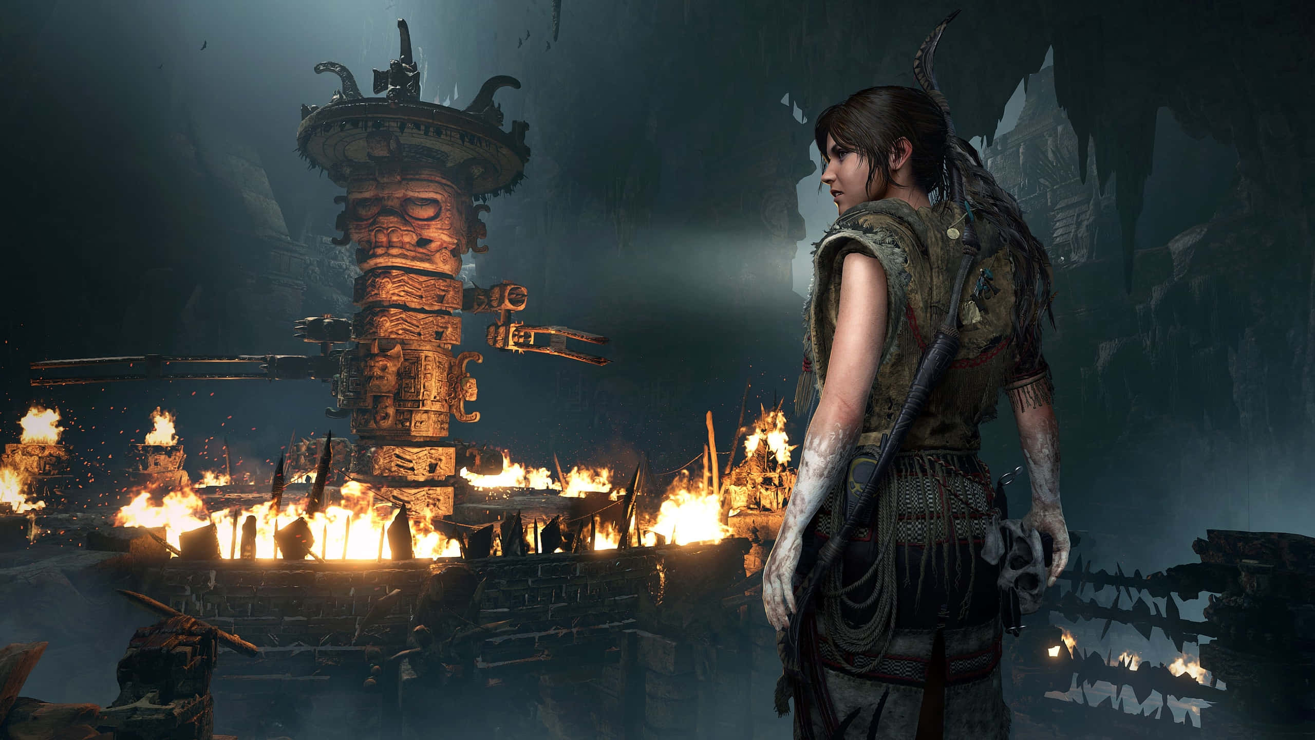 1440p Shadow Of The Tomb Raider 桌布 壁紙 — 一名戰士站在黑暗的洞穴中，古老的廢墟燃燒著猛烈的火焰，照亮了整個場景。