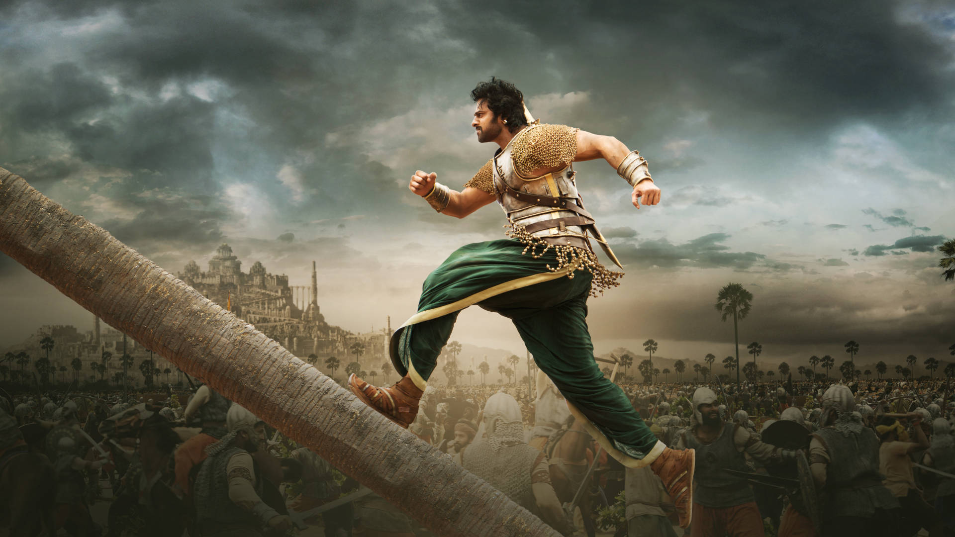 Prabhas HD 桌布 壁紙 — 一名戰士跳過巨大的棕櫚樹幹，下方是戰場，遠處暴風雨中有座城市。