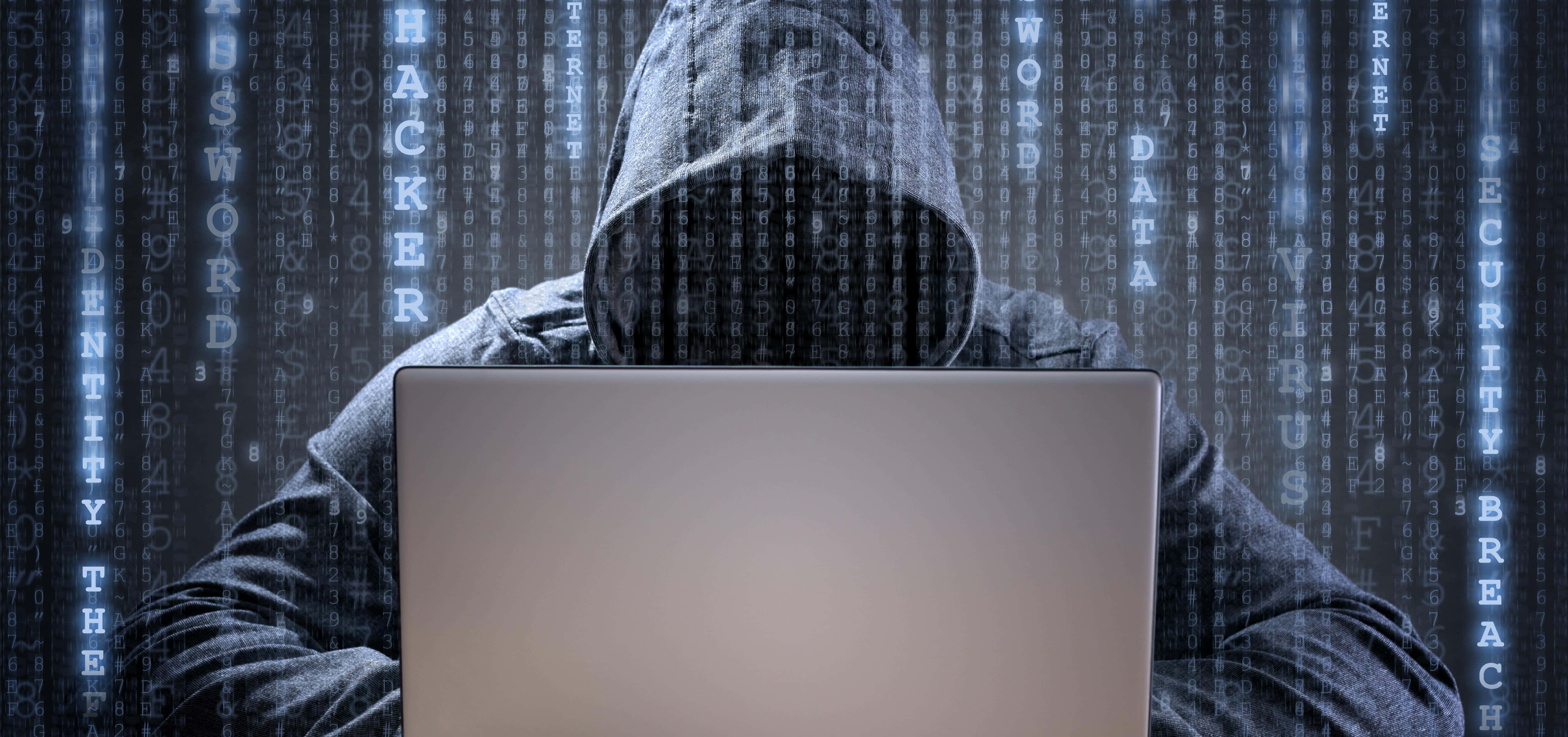Cyber 桌布 壁紙 — 一名戴帽的黑客坐在筆記型電腦前，數位代碼在黑暗的賽博龐克環境中環繞流動。