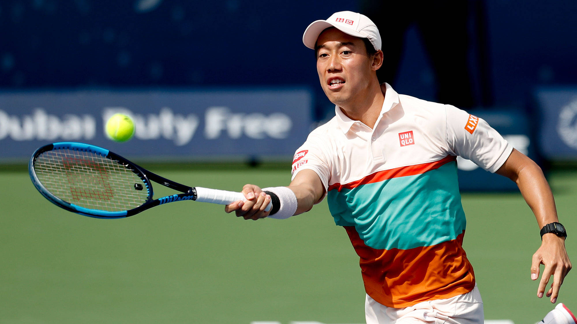 運動 桌布 壁紙 — 一名戴白色帽子、穿彩色襯衫的男網球選手在綠色球場上，於明亮的日光下揮拍擊打一顆黃色球。