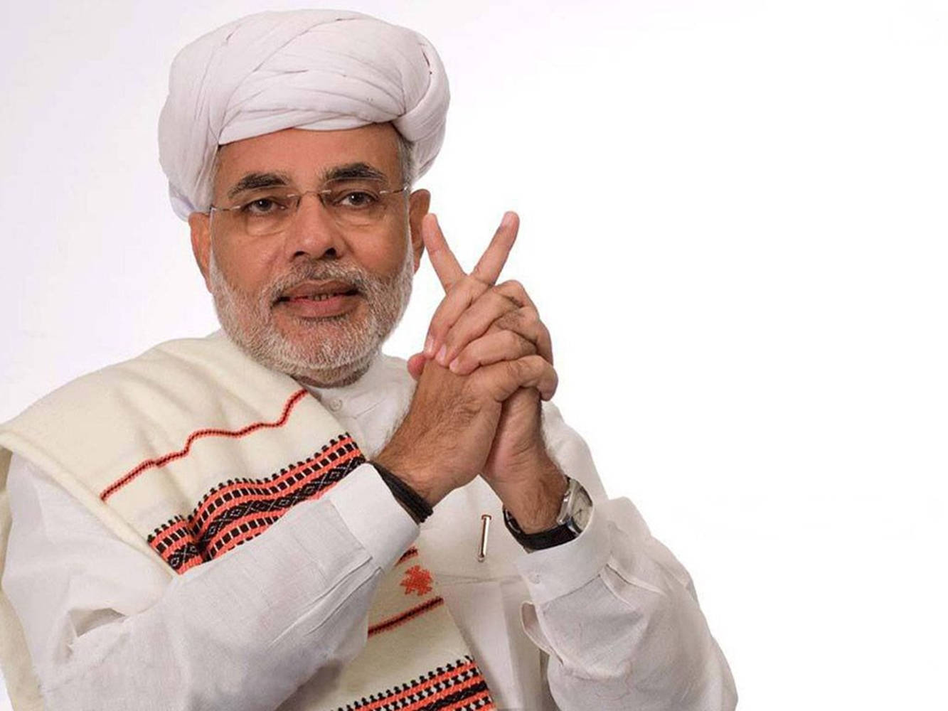 Narendra Modi 桌布 壁紙 — 一名戴白色頭巾、身穿傳統服飾的男子在純白背景前比出和平手勢。