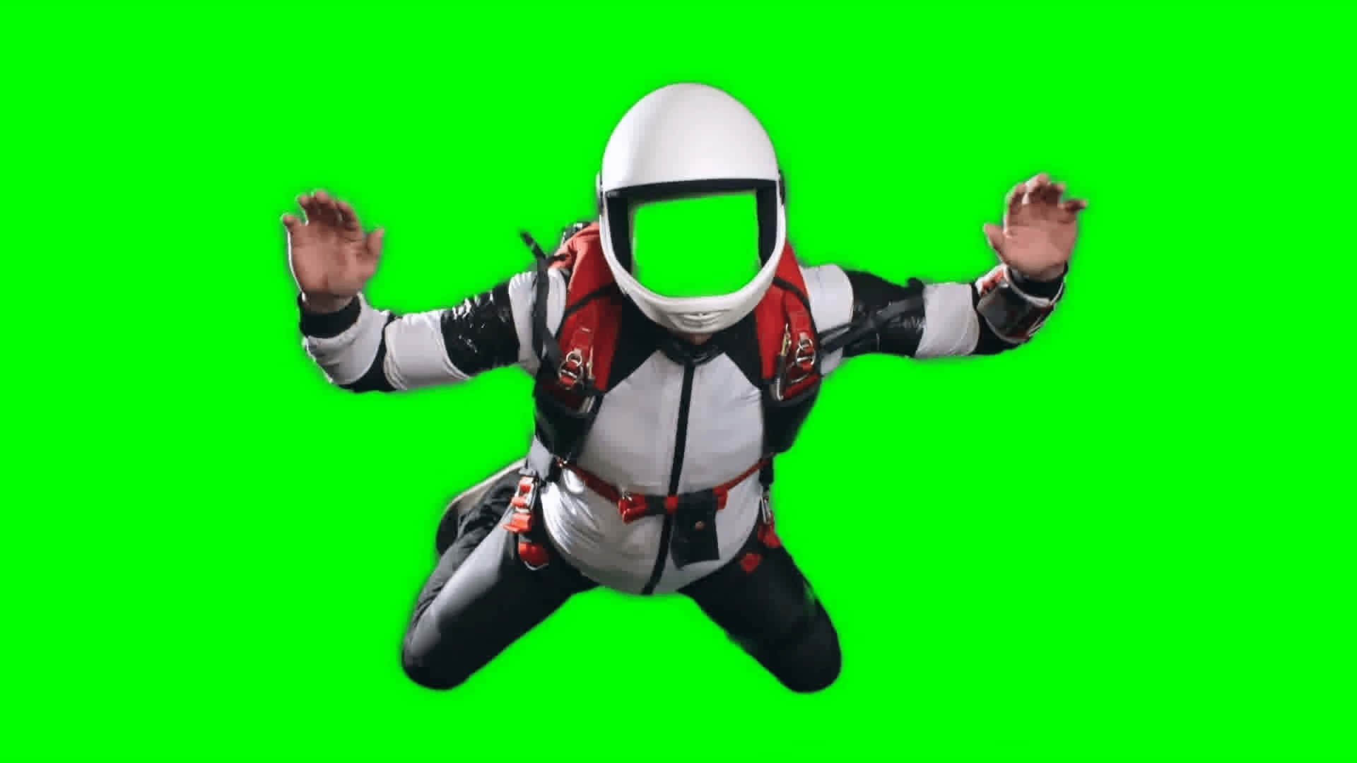 Skydiving 桌布 壁紙 — 一名戴白色頭盔、身穿紅白黑色套裝的跳傘員在純綠色螢幕背景上半空漂浮。