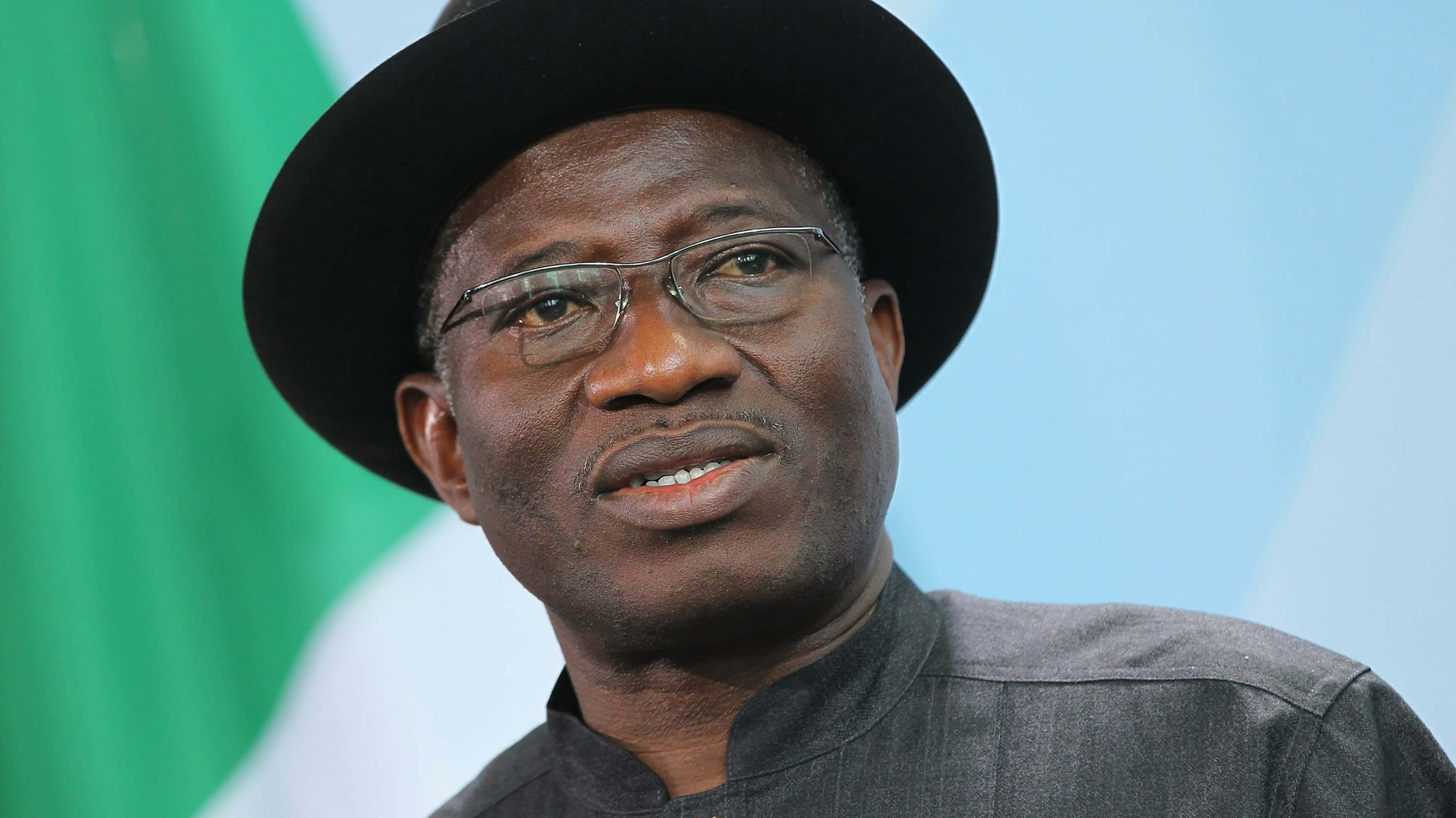 Nigeria 桌布 壁紙 — 一名戴眼鏡和黑色帽子的男子，以奈及利亞國旗為背景的特寫肖像。