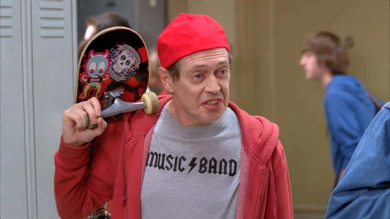 steve buscemi 桌布 壁紙 — 一名戴紅色毛帽、穿連帽上衣的男子站在學校走廊，手持一塊帶有卡通圖案的滑板。
