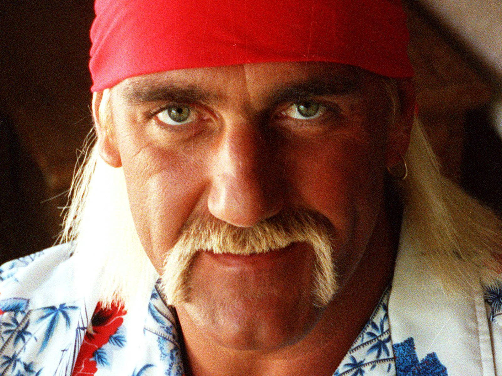 Hulk Hogan 桌布 壁紙 — 一名戴紅色頭巾、留鬍鬚、身穿熱帶襯衫的男士的特寫肖像。