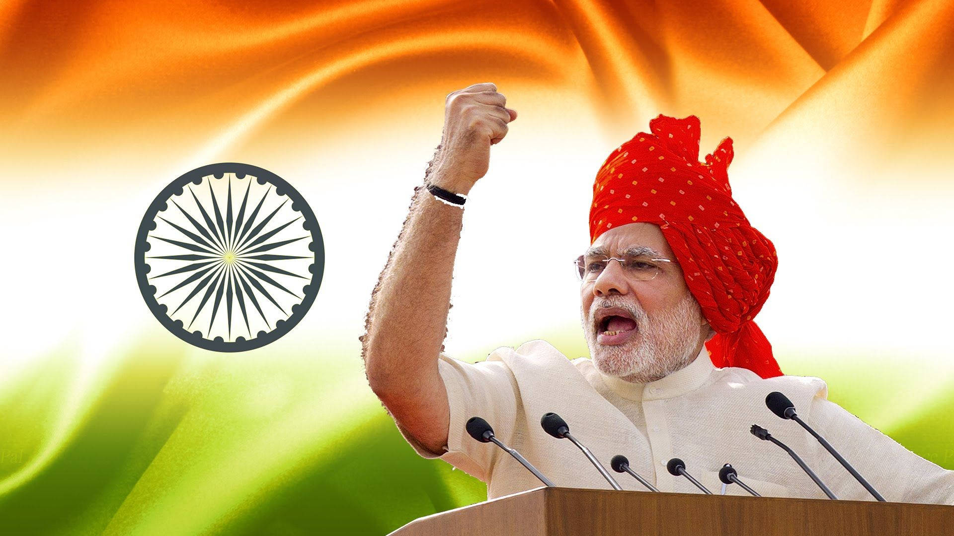 Narendra Modi 桌布 壁紙 — 一名戴紅色頭巾的男子在講台上熱情地舉起拳頭，背景是飄揚的印度國旗。