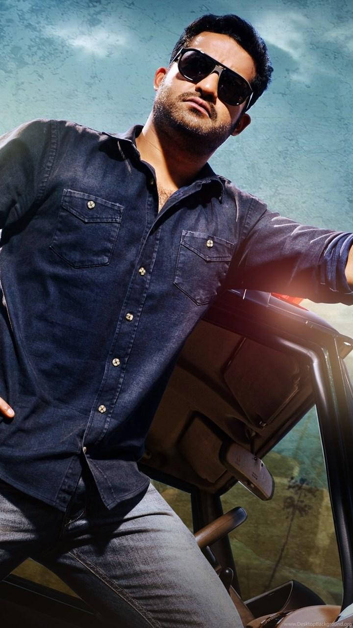 jr ntr 桌布 壁紙 — 一名戴著太陽眼鏡和牛仔襯衫的男子在明亮的天空下自信地靠在一輛車上。