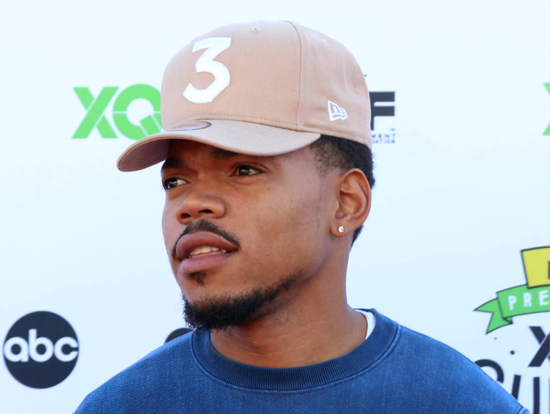 chance 桌布 壁紙 — 一名戴著米色帽子、上面有白色數字三、身穿藍色運動衫的男子站在帶有標誌的背景前。