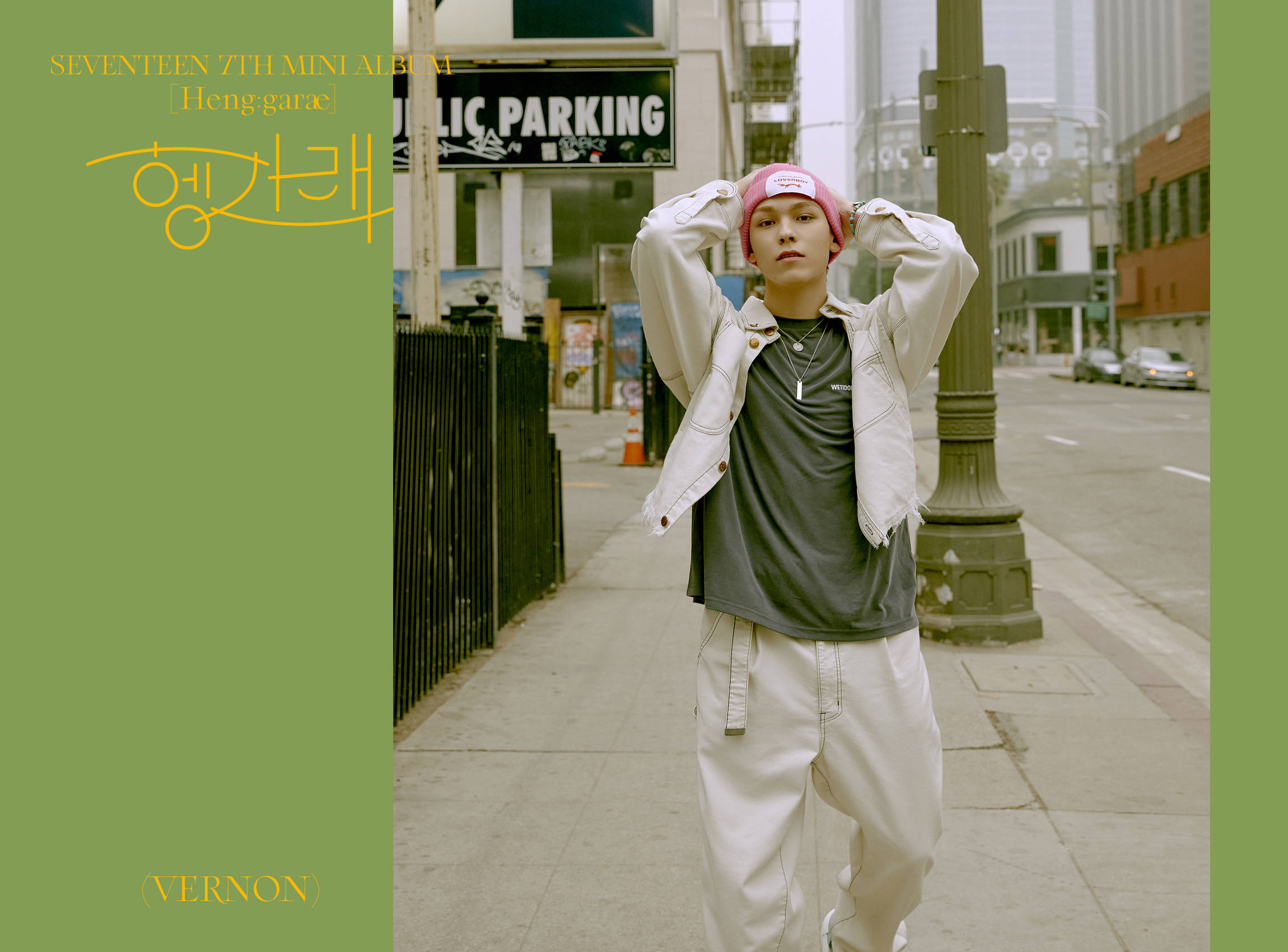 Vernon 桌布 壁紙 — 一名戴著粉紅色毛帽和白色外套的年輕男子，在城市人行道上，在「PUBLIC PARKING」標誌旁邊調整帽子。
