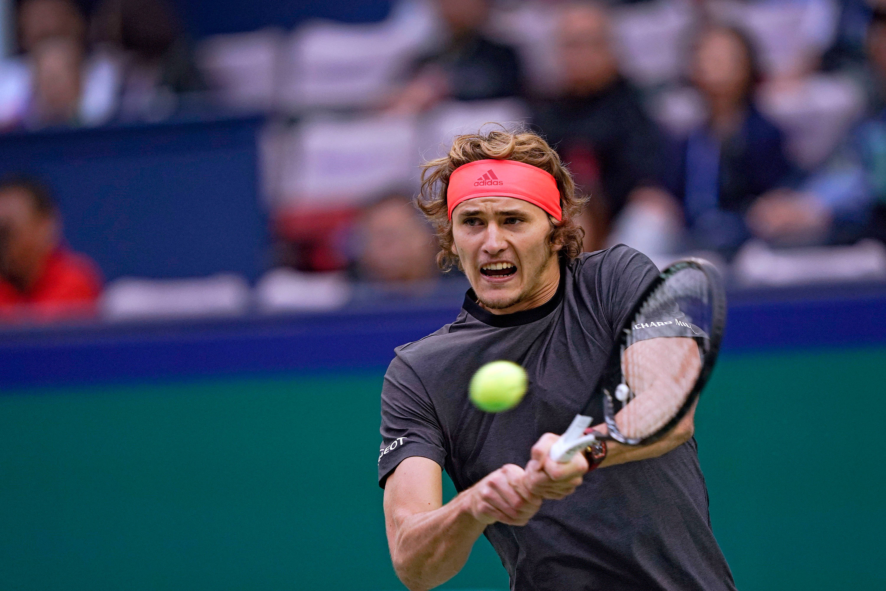 alexander zverev 桌布 壁紙 — 一名戴著紅色頭帶的男性網球選手在激烈的比賽中揮拍擊向一顆亮黃色的球。