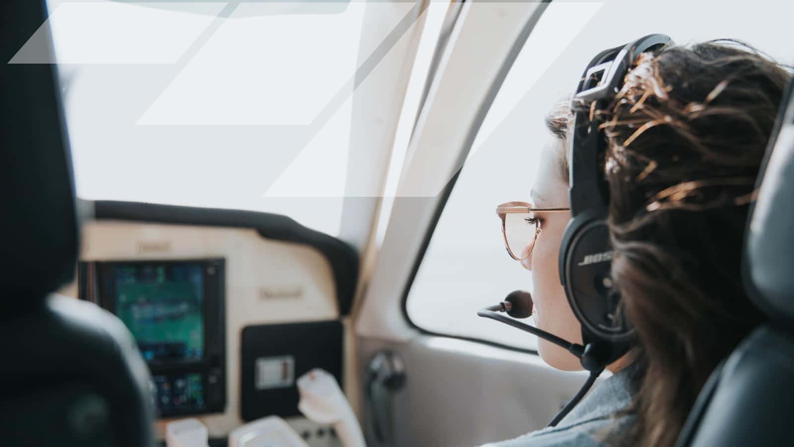 Plane 桌布 壁紙 — 一名戴著耳機和眼鏡的飛行員專注地坐在小型飛機的駕駛艙內，望向窗外。