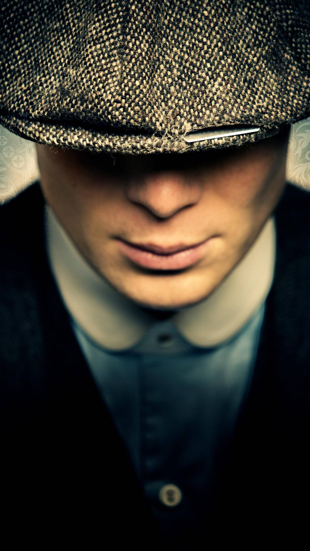 戴著平頂帽和襯衫領的男子，表情嚴肅。 — Peaky Blinders 壁紙