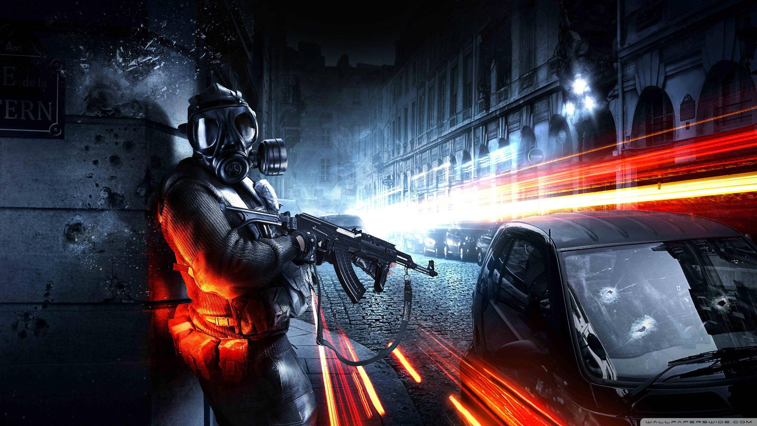 Battlefield 3 桌布 壁紙 — 一名戴著防毒面具的士兵在夜晚的廢墟城市街道上開步槍，有發光的紅色光跡和佈滿彈孔的汽車。