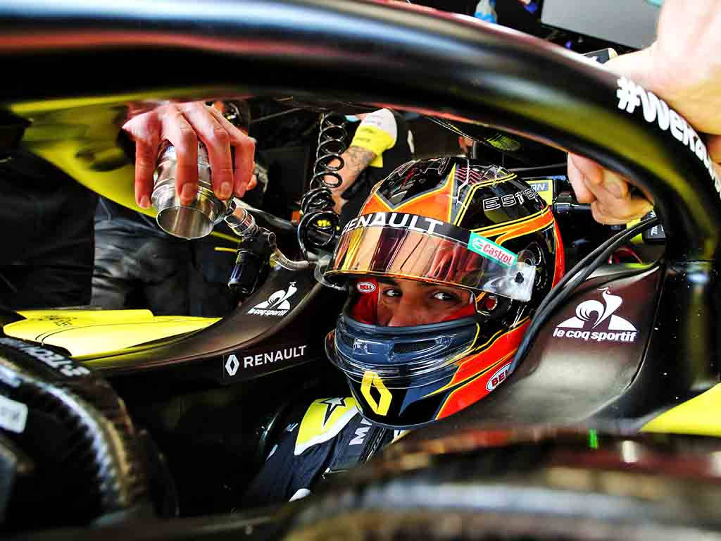 F1 桌布 壁紙 — 一名戴著雷諾頭盔的F1車手在駕駛艙內從維修站工作人員手中接過飲料。
