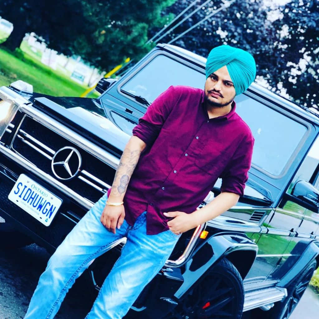 戴頭巾的男子在公園裡靠著豪華 SUV — Sidhu Moose Wala 壁紙