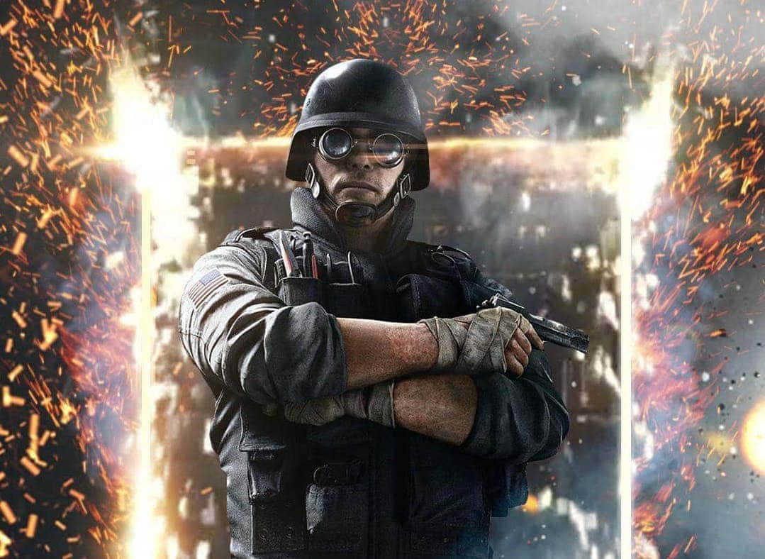 Rainbow Six Siege Thermite 桌布 壁紙 — 一名戴著頭盔和護目鏡的士兵，在戰區中燃燒的爆炸和發光的光束中堅定地站立。