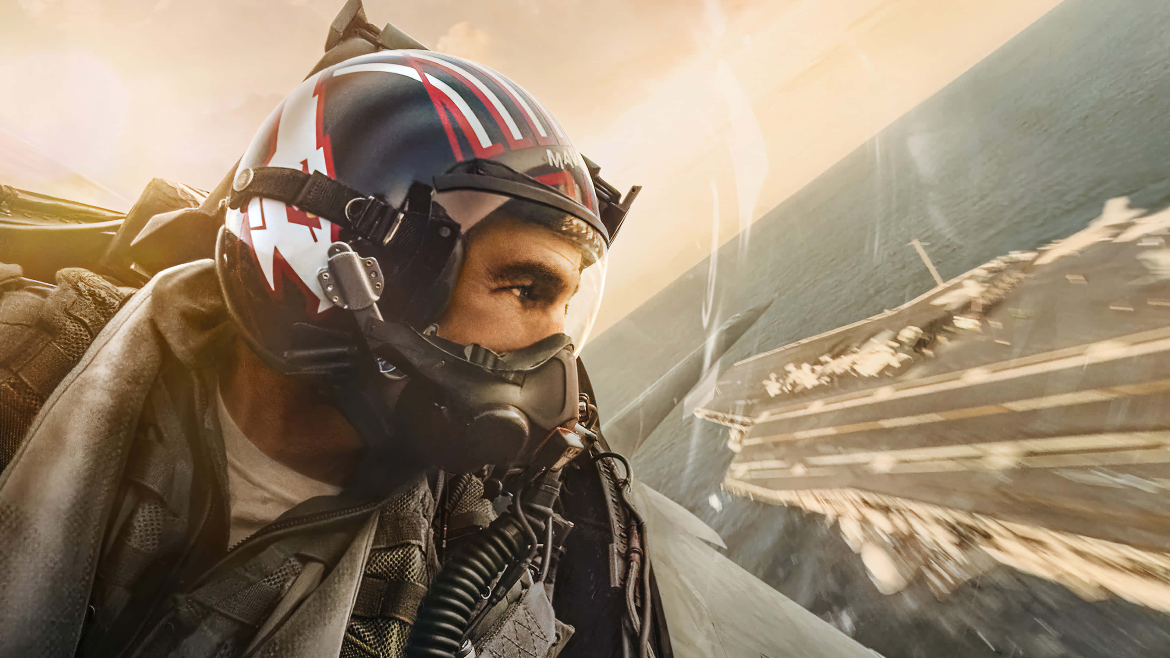 Rainbow Six Siege Maverick 桌布 壁紙 — 一名戴著頭盔的戰鬥機飛行員向前凝視，他的噴射機在日出時掠過航空母艦甲板。