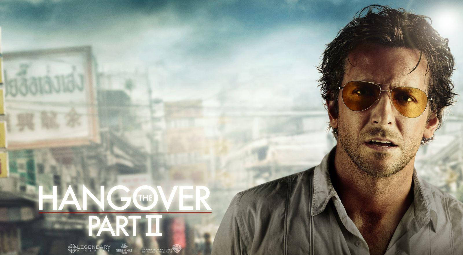 the hangover 桌布 壁紙 — 一名戴著飛行員太陽眼鏡的男子，在模糊的城市背景下，帶著泰文標誌和電影標題，凝視著前方。