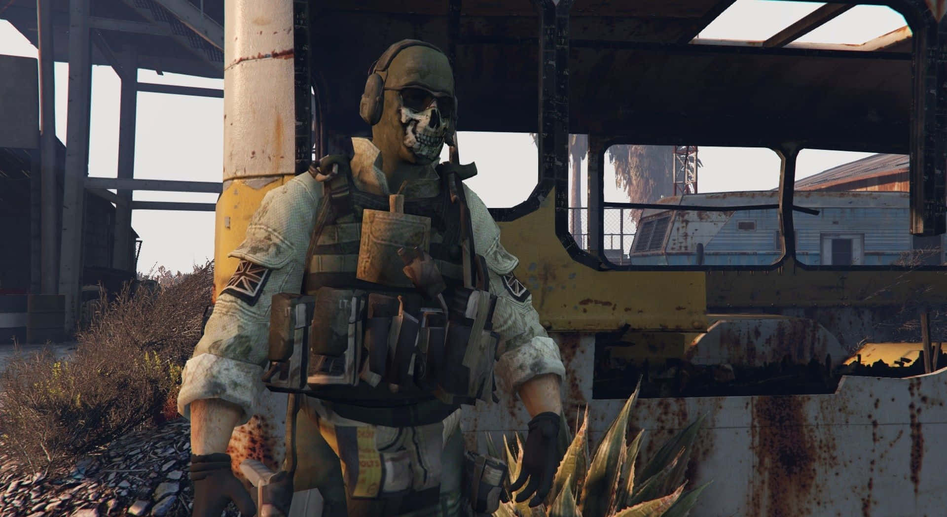 Simon Ghost Riley 桌布 壁紙 — 一名戴著骷髏面具和戰術裝備的士兵站在荒涼工業廢墟中生鏽的黃色車輛旁。
