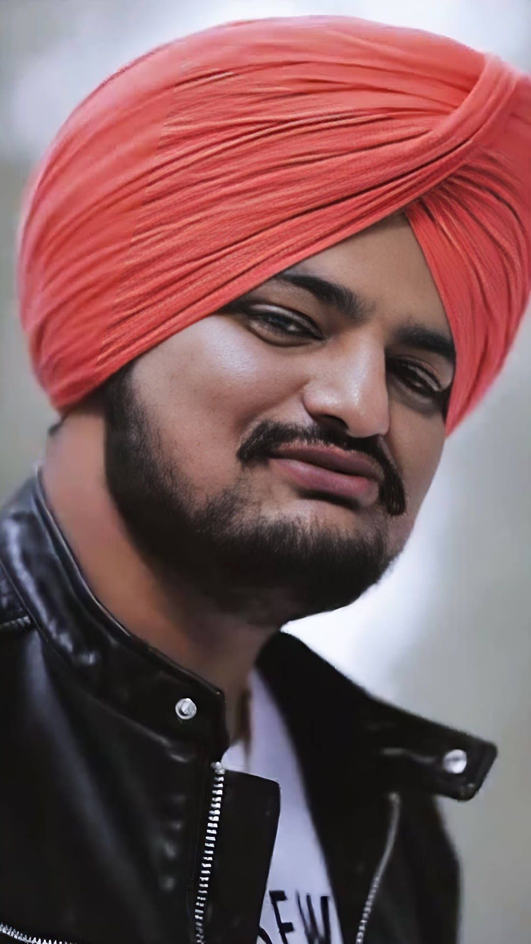 戴紅色頭巾和黑色皮夾克的男子微笑 — Sidhu Moose Wala 壁紙