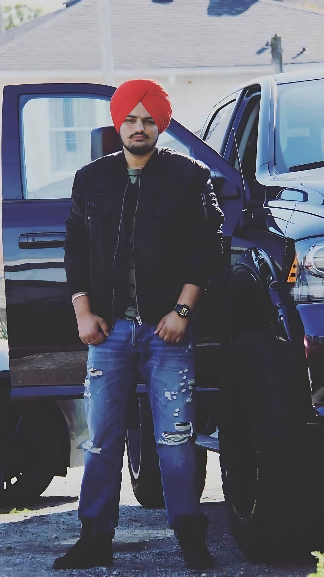 戴紅色頭巾的男子站在黑色皮卡車旁 — Sidhu Moose Wala 壁紙
