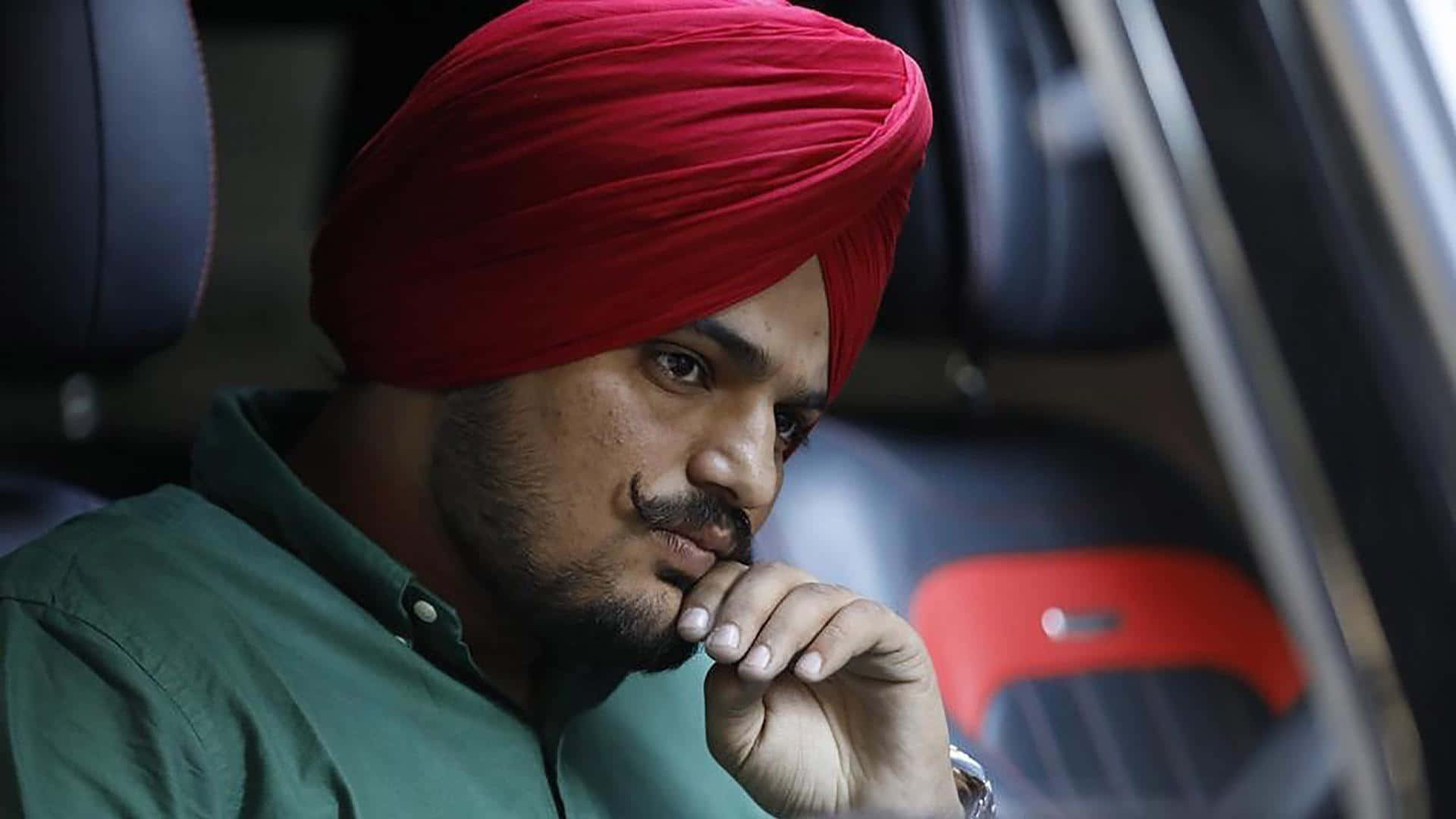 戴紅色頭巾的男子坐在車內沉思 — Sidhu Moose Wala 壁紙