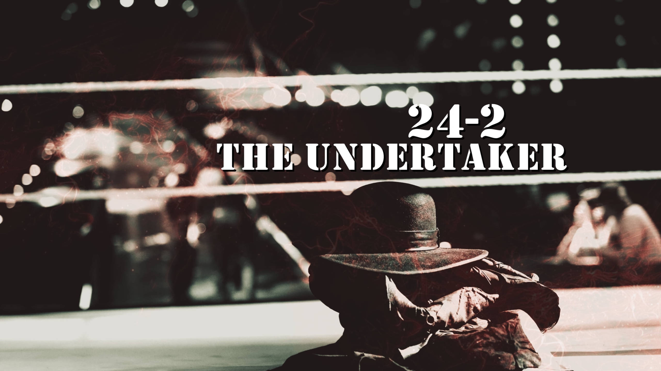 Undertaker 桌布 壁紙 — 一名戴黑色帽子和外套的摔角手在明亮的燈光下莊嚴地坐在擂台上，帶有'24-2 THE UNDERTAKER'文字。