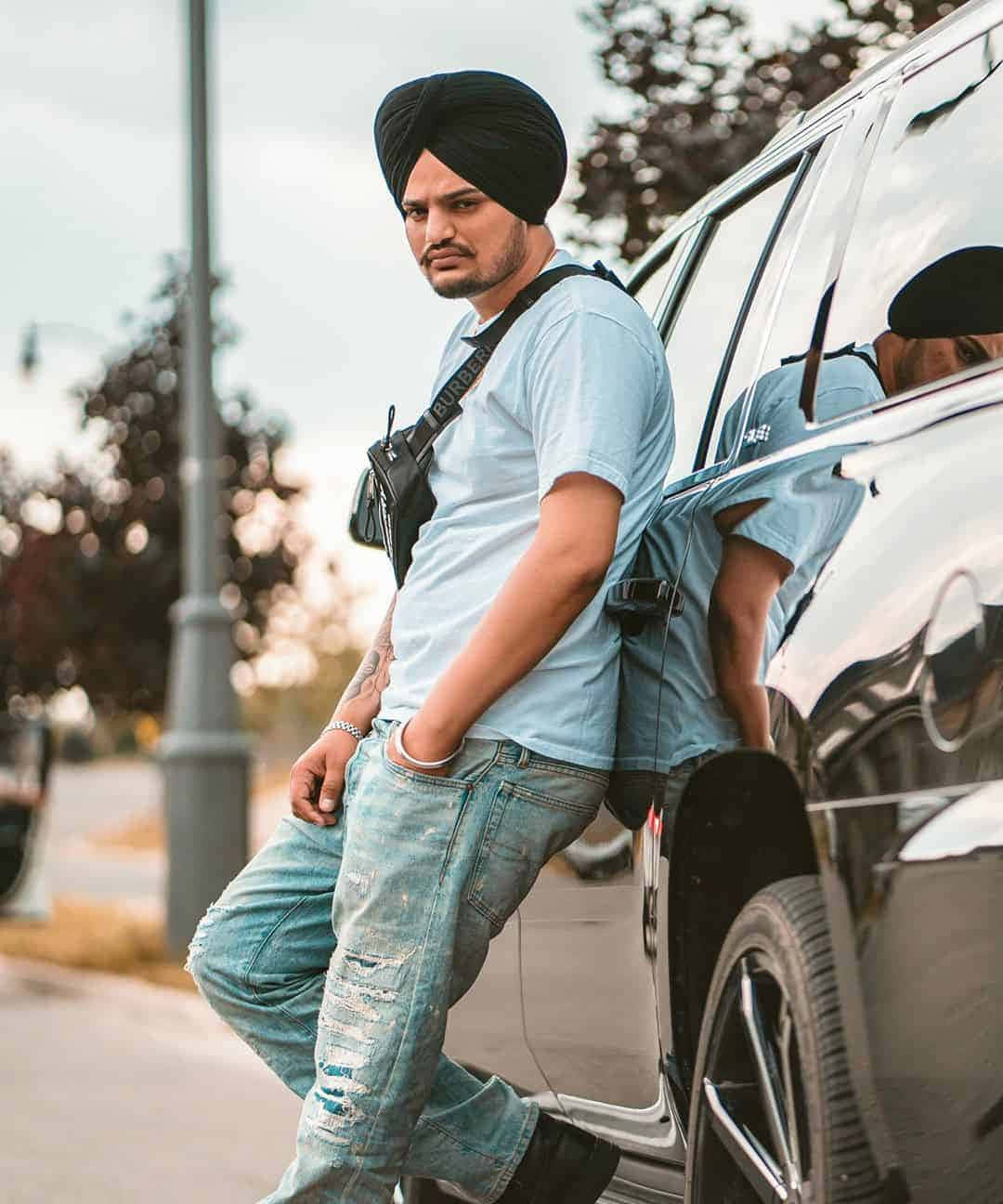 戴頭巾男子靠在街上黑色SUV旁 — Sidhu Moose Wala 壁紙