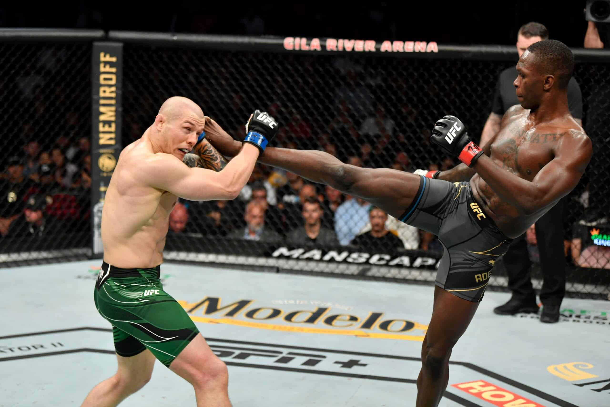 MMA 桌布 壁紙 — 一名拳手在UFC八角籠中向對手使出高踢，觀眾和場館品牌清晰可見。