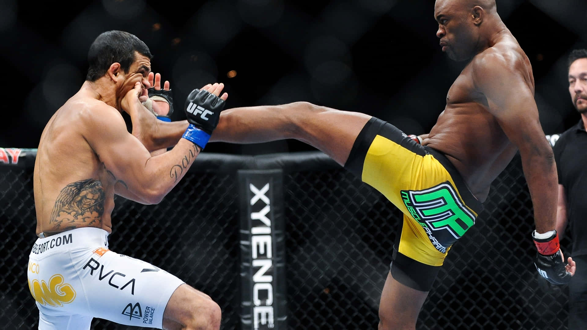 UFC 桌布 壁紙 — 一名拳手在明亮的場館燈光下，於UFC八角籠中向對手使出高踢。