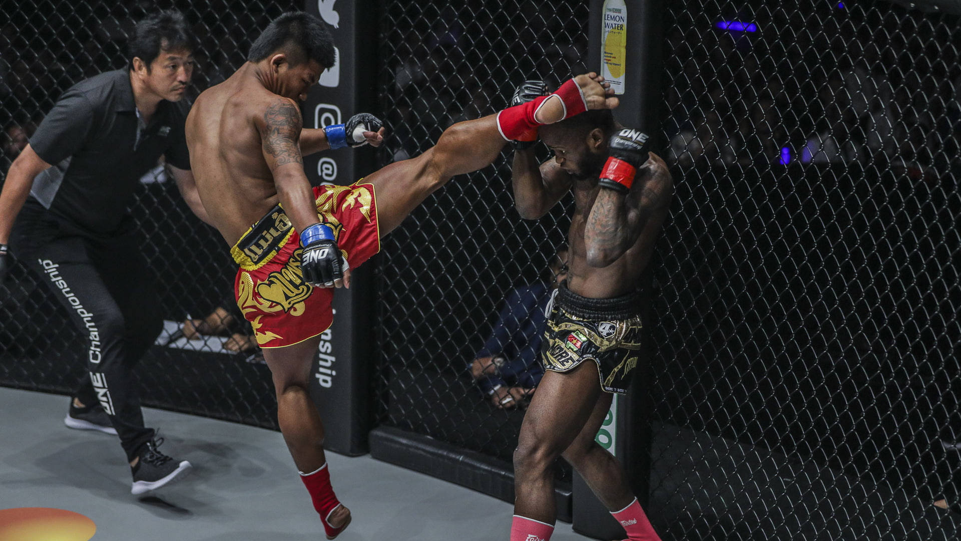 MMA 桌布 壁紙 — 一名拳手在明亮的場館燈光下，於綜合格鬥籠內向對手施展高踢。