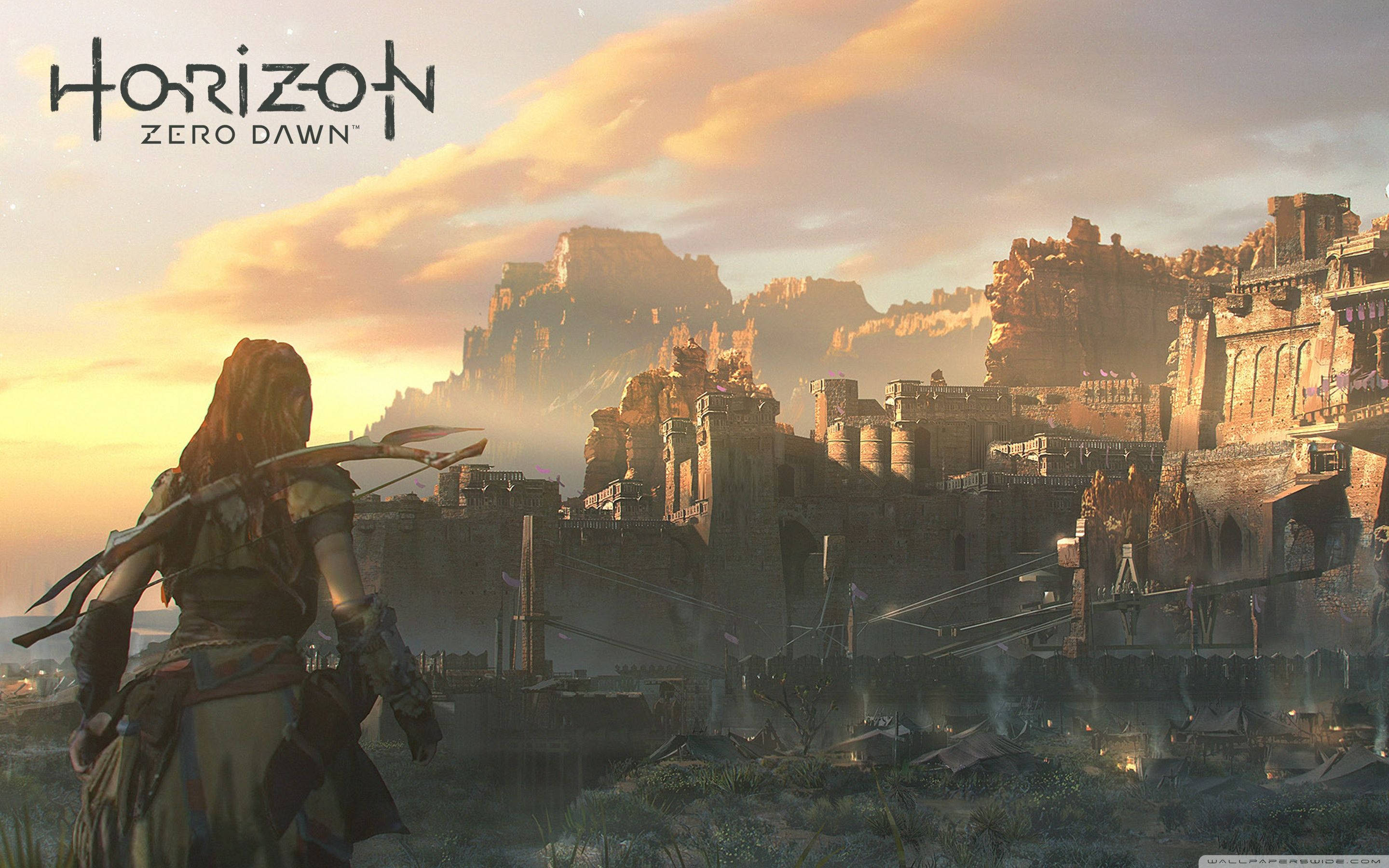 Horizon 桌布 壁紙 — 一名持弓戰士站在廣闊的廢墟城市前，背景是金色夕陽和霧氣繚繞的山脈。