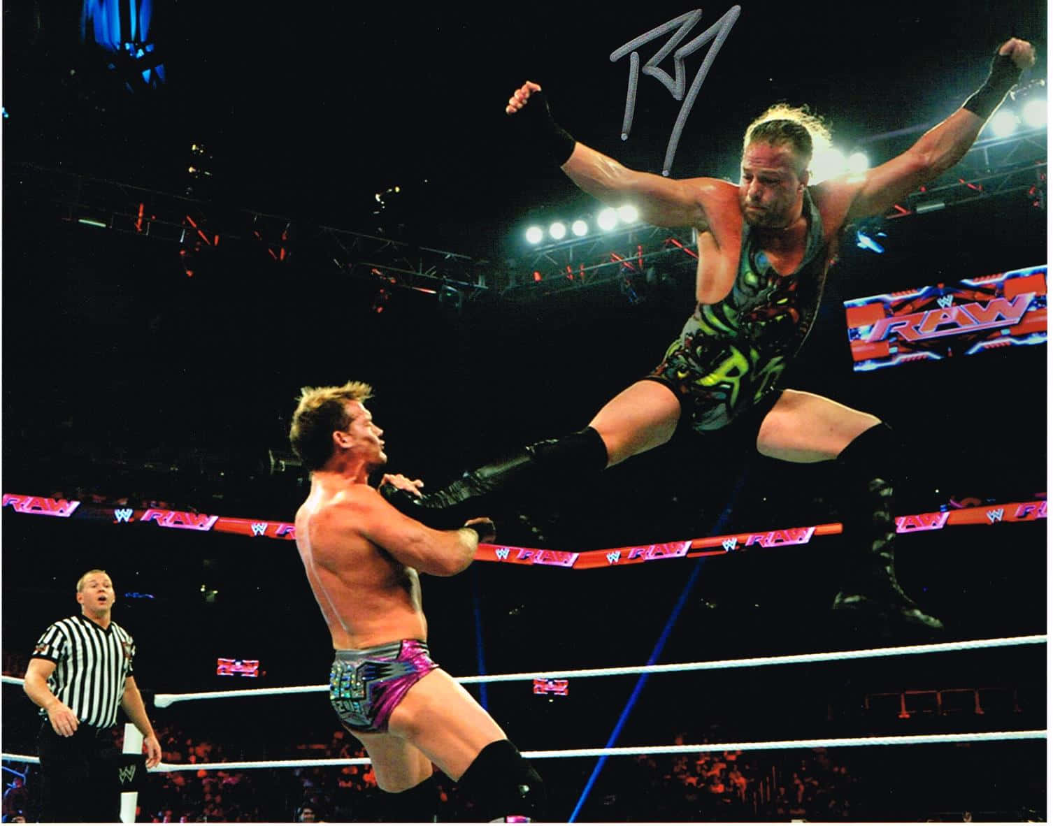 WWE 桌布 壁紙 — 一名摔角手在WWE RAW賽事中，於燈光明亮的擂台上躍向對手，裁判在旁觀看。