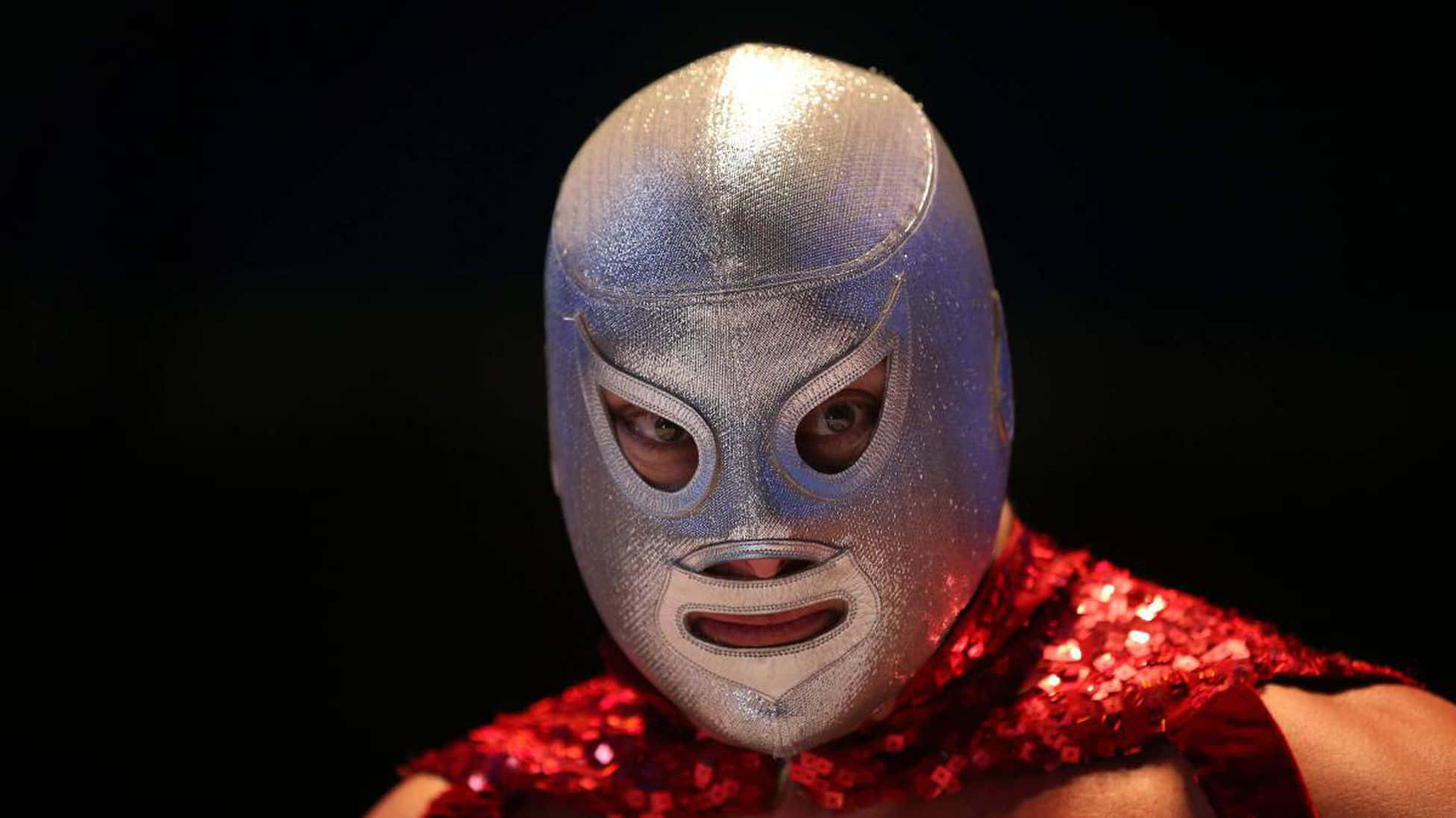 Mexican 桌布 壁紙 — 一名摔角手戴著閃亮的銀色面具和紅色亮片上衣，在黑色背景下凝視著。