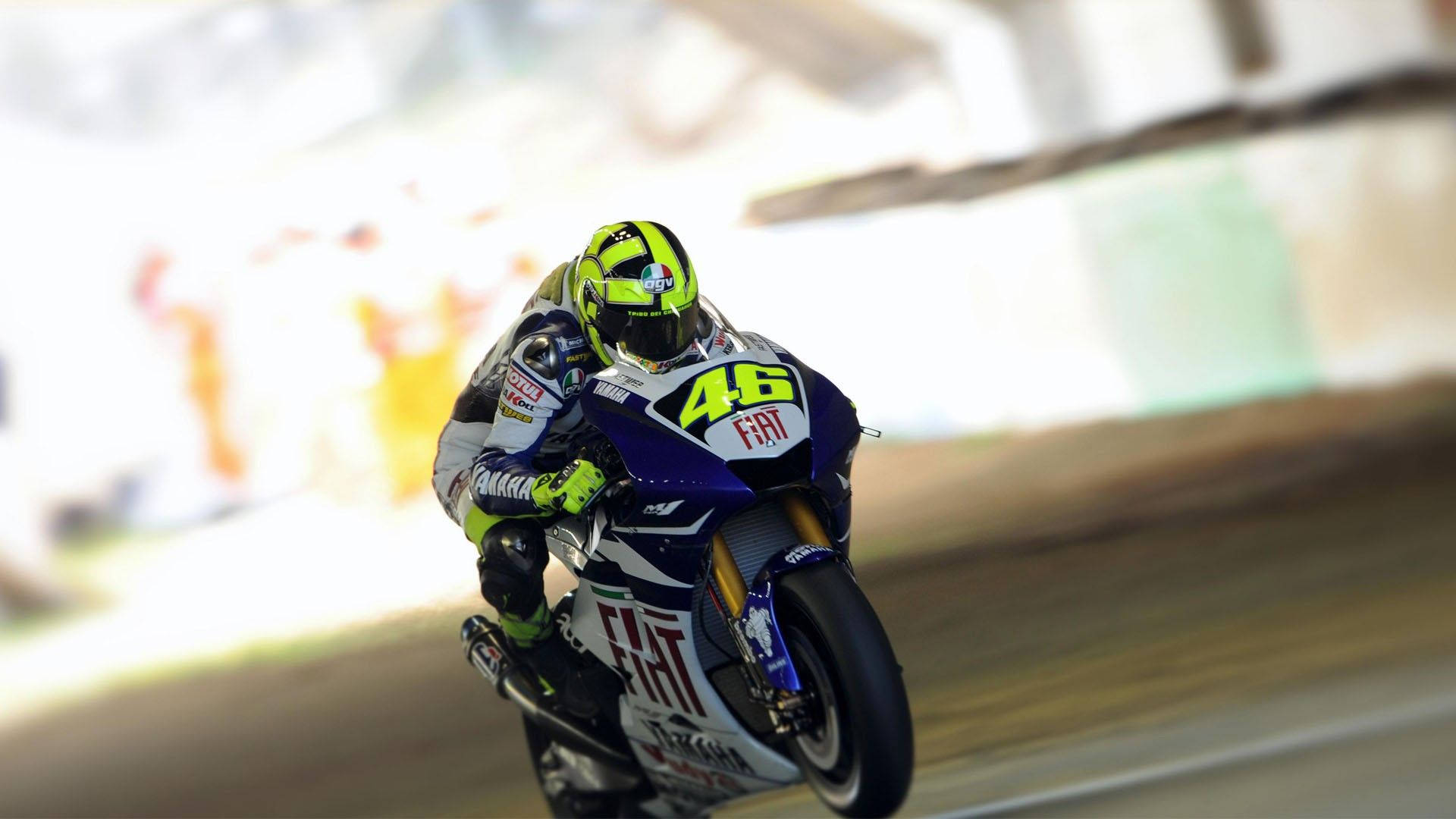 Racing 桌布 壁紙 — 一名摩托車賽車手在賽道上傾斜入彎，戴著亮綠色頭盔和46號賽車服。