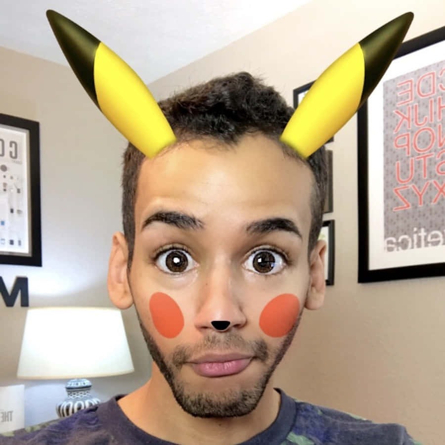 Snapchat 桌布 壁紙 — 一名擁有皮卡丘耳朵和臉頰的男子在室內擺出驚訝的表情。