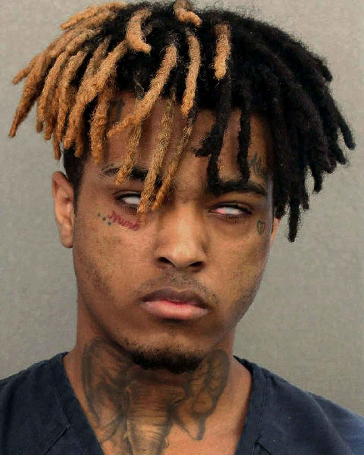 XXXTENTACION 桌布 壁紙 — 一名擁有黑色和金色辮子、頸部和臉部有明顯刺青的男子特寫大頭照。