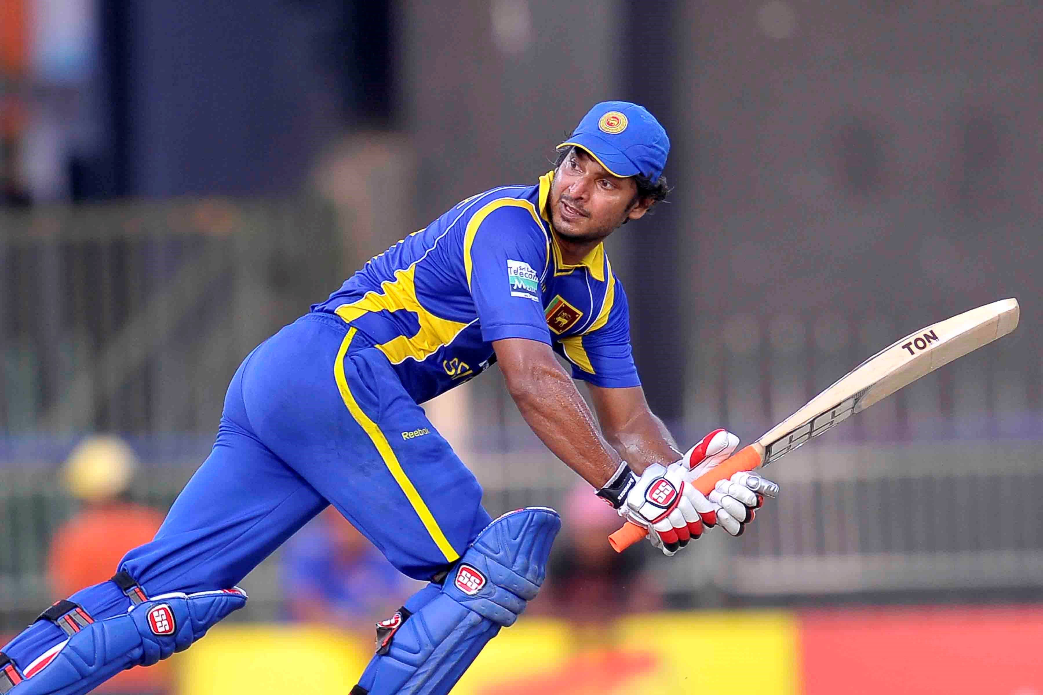 Sri Lanka Cricket 桌布 壁紙 — 一名斯里蘭卡板球運動員身穿藍黃色球衣，在比賽中專注地揮動球棒。