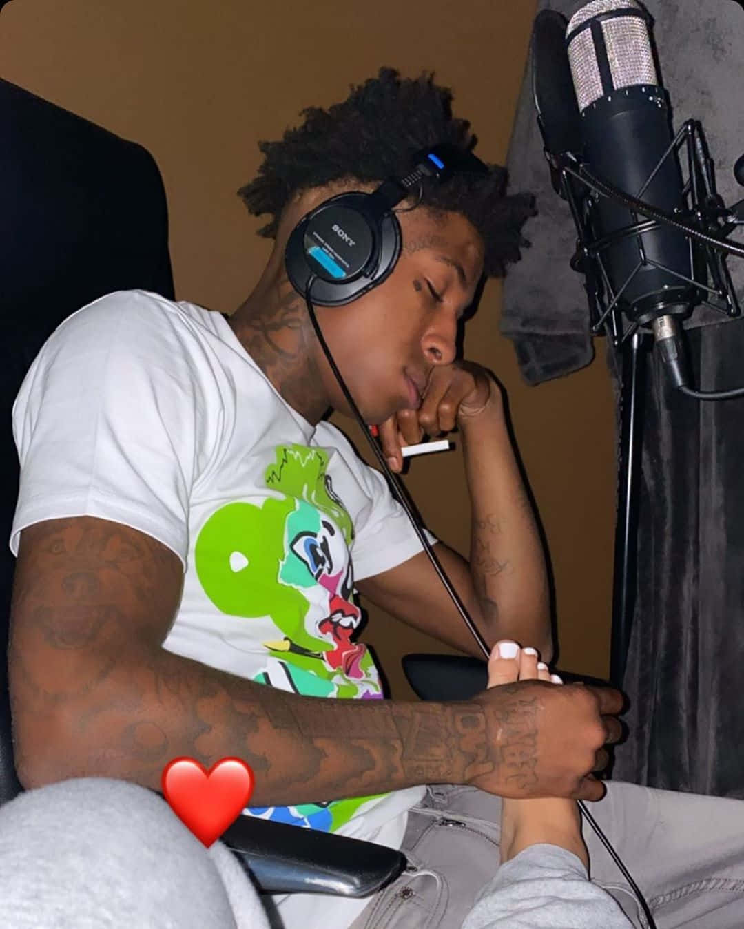 Youngboy 桌布 壁紙 — 一名有刺青的年輕男子戴著耳機，手持香菸，在錄音室麥克風旁邊的椅子上睡覺。