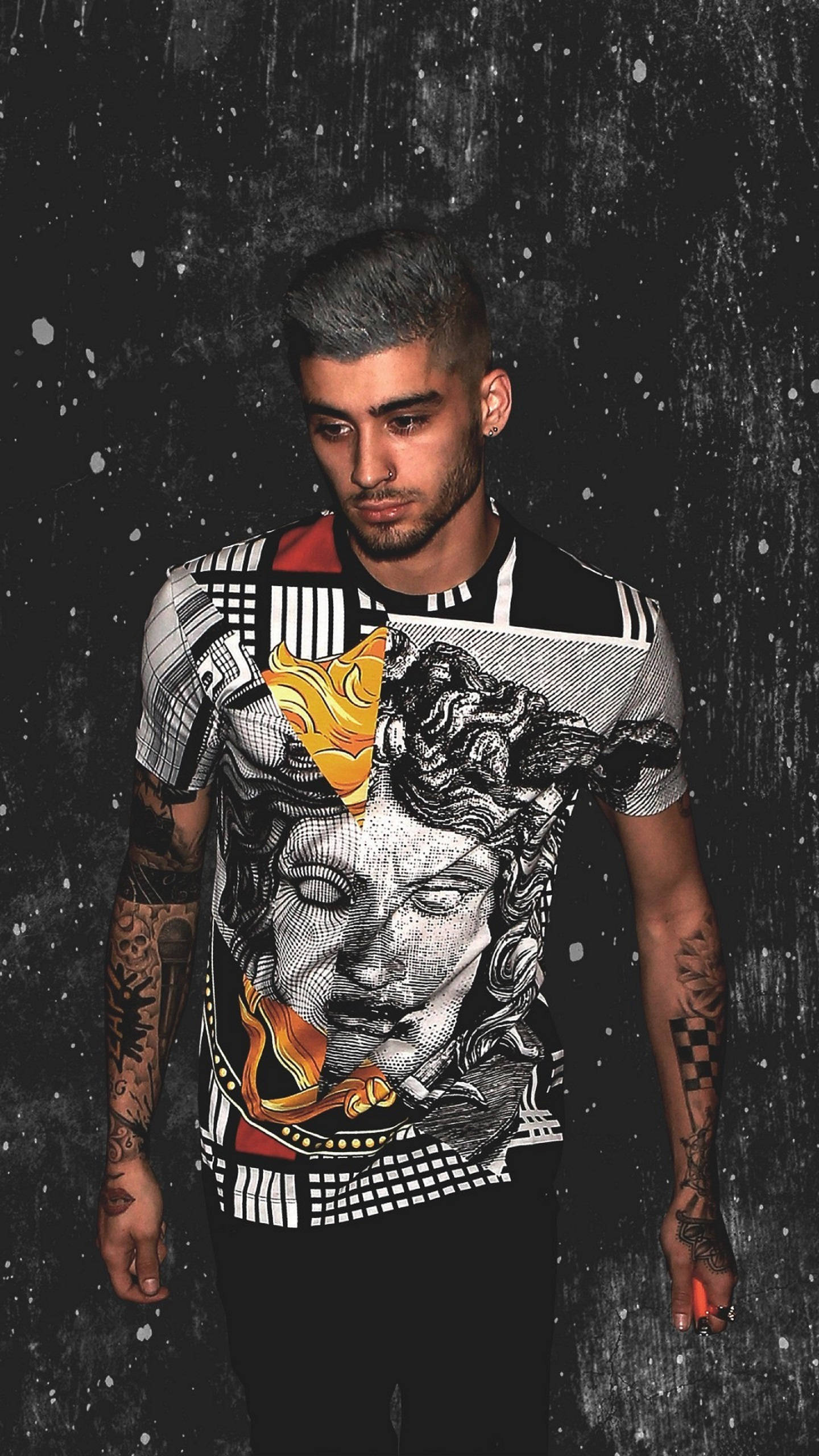 zayn 桌布 壁紙 — 一名有刺青的男子穿著印有梅杜莎頭像和火焰的圖案T恤，背景是深色潑墨牆。