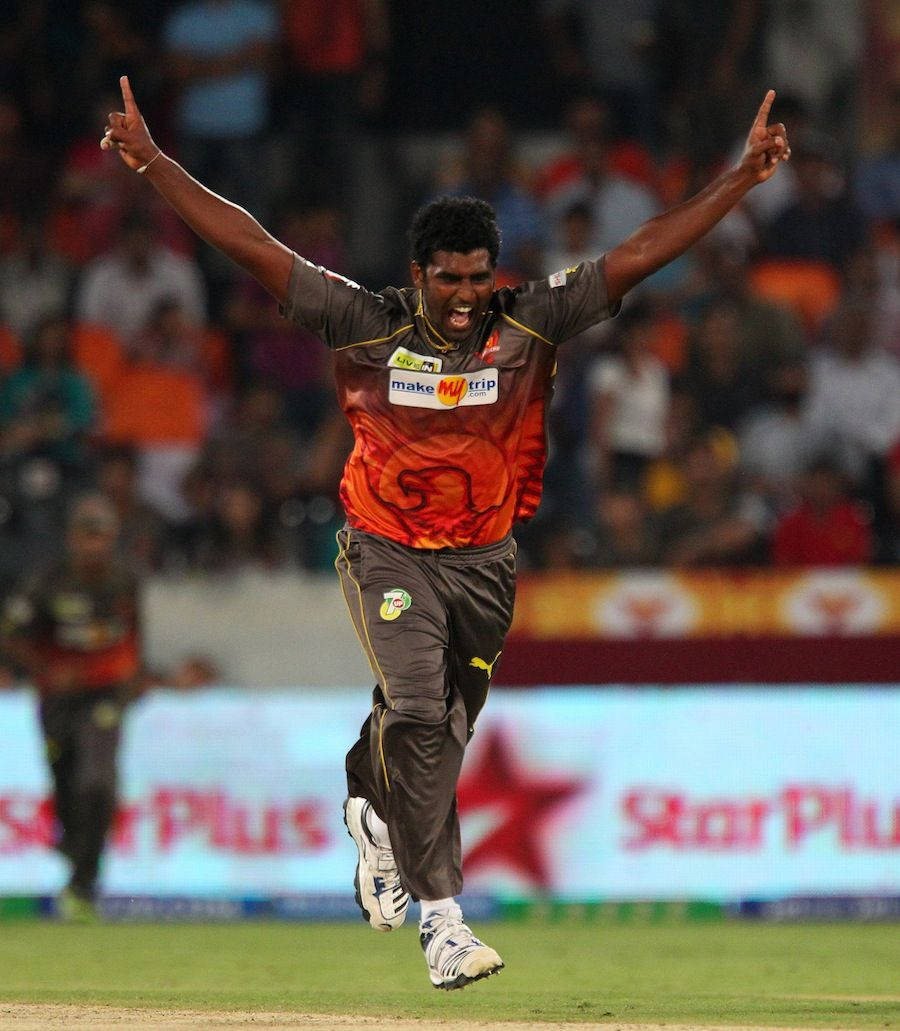 Sunrisers Hyderabad 桌布 壁紙 — 一名板球運動員在燈火通明的體育場上，高舉雙臂，歡欣跳躍慶祝勝利。