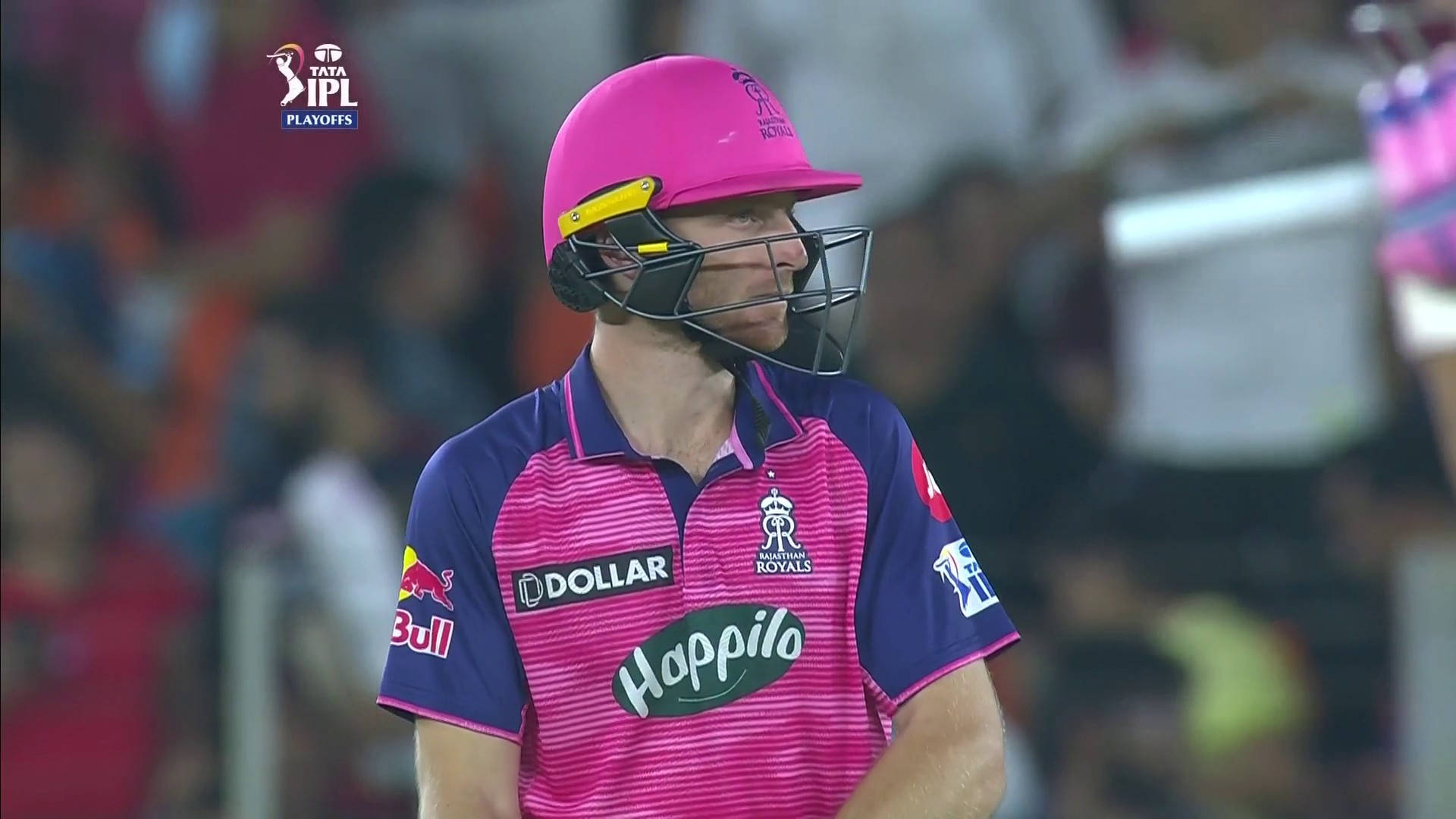 jos buttler 桌布 壁紙 — 一名板球運動員戴著鮮粉紅色頭盔和球衣，在體育場燈光下專注地站著進行 IPL 比賽。